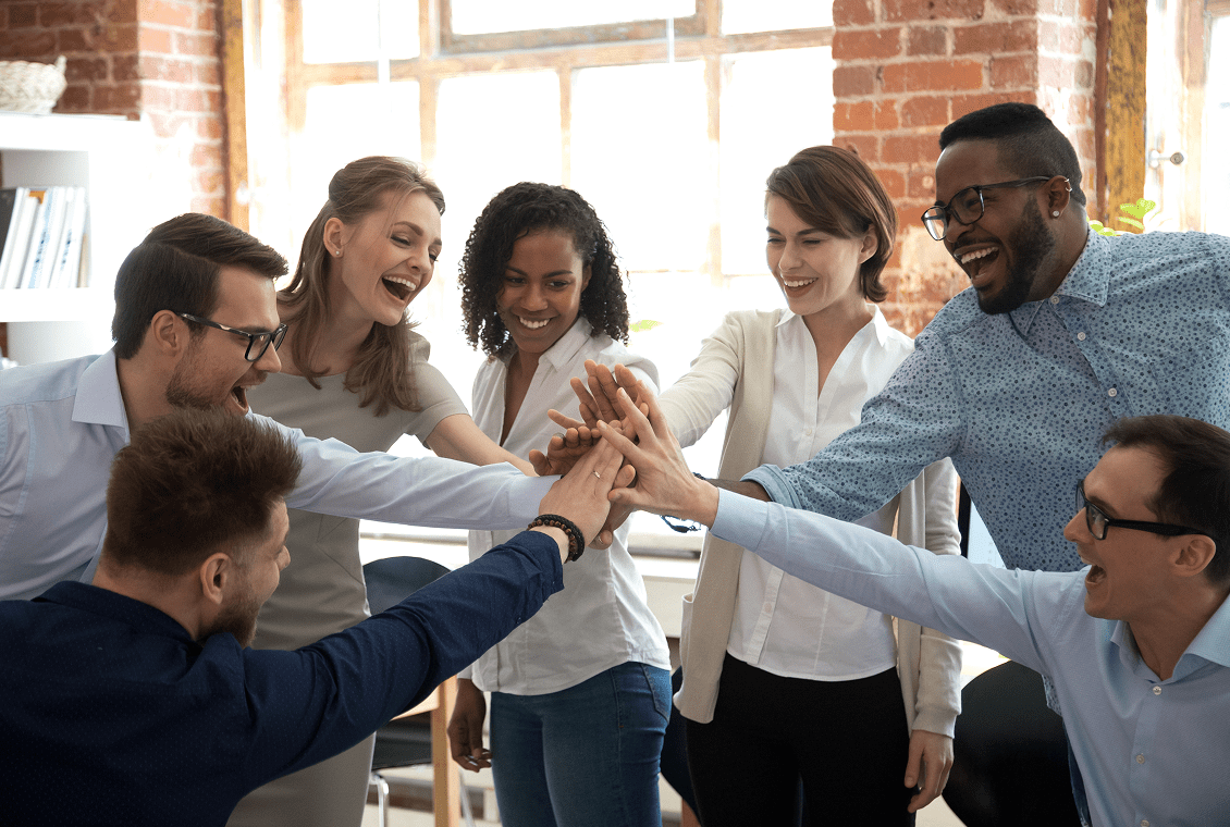 Diverse colleagues joining hands in unity.